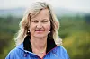 Kristin Krohn Devold står utendørs foran en uskarp grønn bakgrunn.