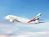 Emirates-passasjerfly i luften mot blå himmel og lyse skyer.