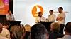 Paneldebatt med fire deltakere på en scene og publikum i forgrunnen.