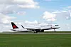 Air Canada-fly på en rullebane med gress og blå himmel