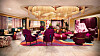 Elegant hotell-lounge med gjester i fargerike lenestoler og sofaer.