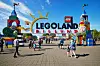 Besøkende foran inngangen til LEGOLAND Billund med fargerike tårn og stor parklogo.