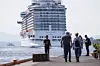 Regal Princess ligger til kai i Oslo, med mennesker på bryggen og fjell i bakgrunnen.