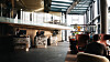 Moderne lobby med sittegrupper, planter, mesanin og glasstak.