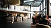 Moderne lobby med sittegrupper, planter, mesanin og glasstak.