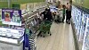 Kunde med handlevogn går gjennom en supermarkedsgang med kjøledisker.