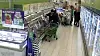 Kunde med handlevogn går gjennom en supermarkedsgang med kjøledisker.