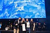 Gruppe mennesker samlet på en scene foran en blå prisbanner med teksten DLF Bærekraftpris og JDE.