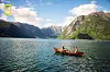 Robåt med to personer på en fjord omgitt av bratte fjell.